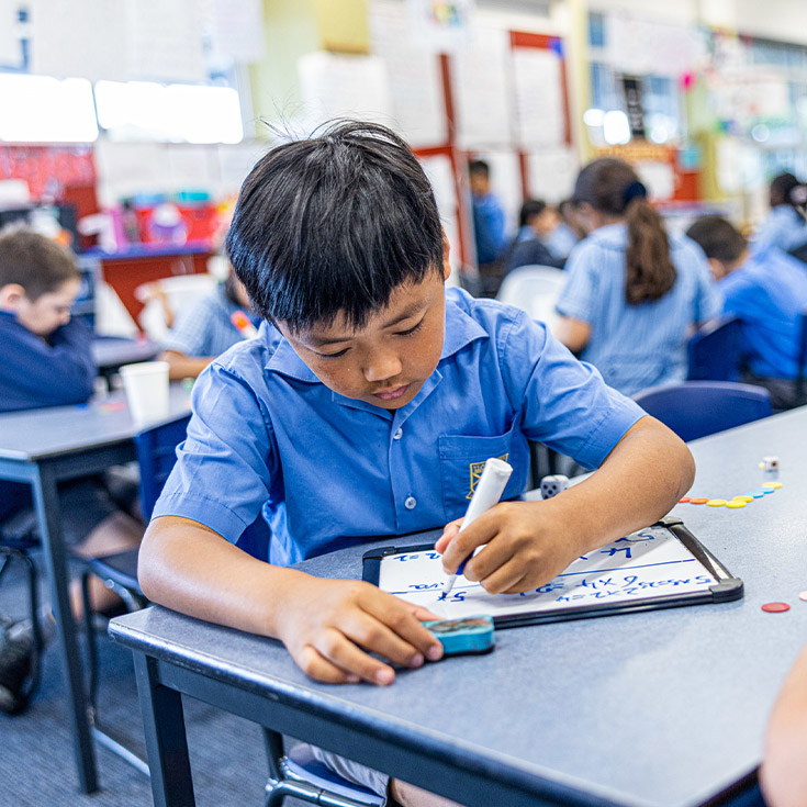 Student learning math in the classroom at St Andrews Primary School Marayong