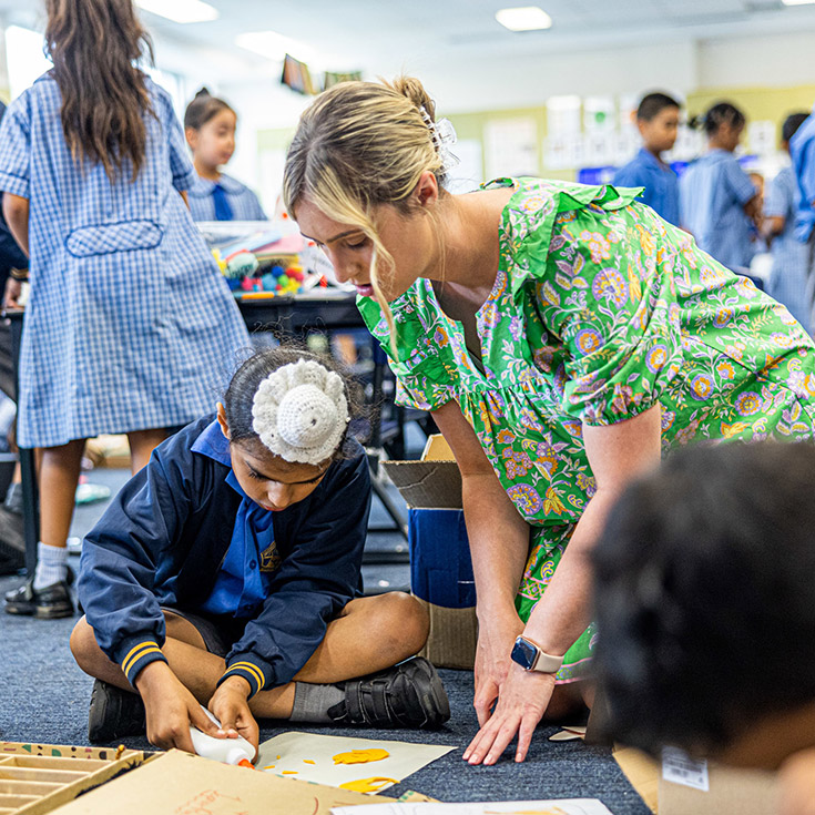 Teacher helping a student with his art project at St Andrews Primary School Marayong